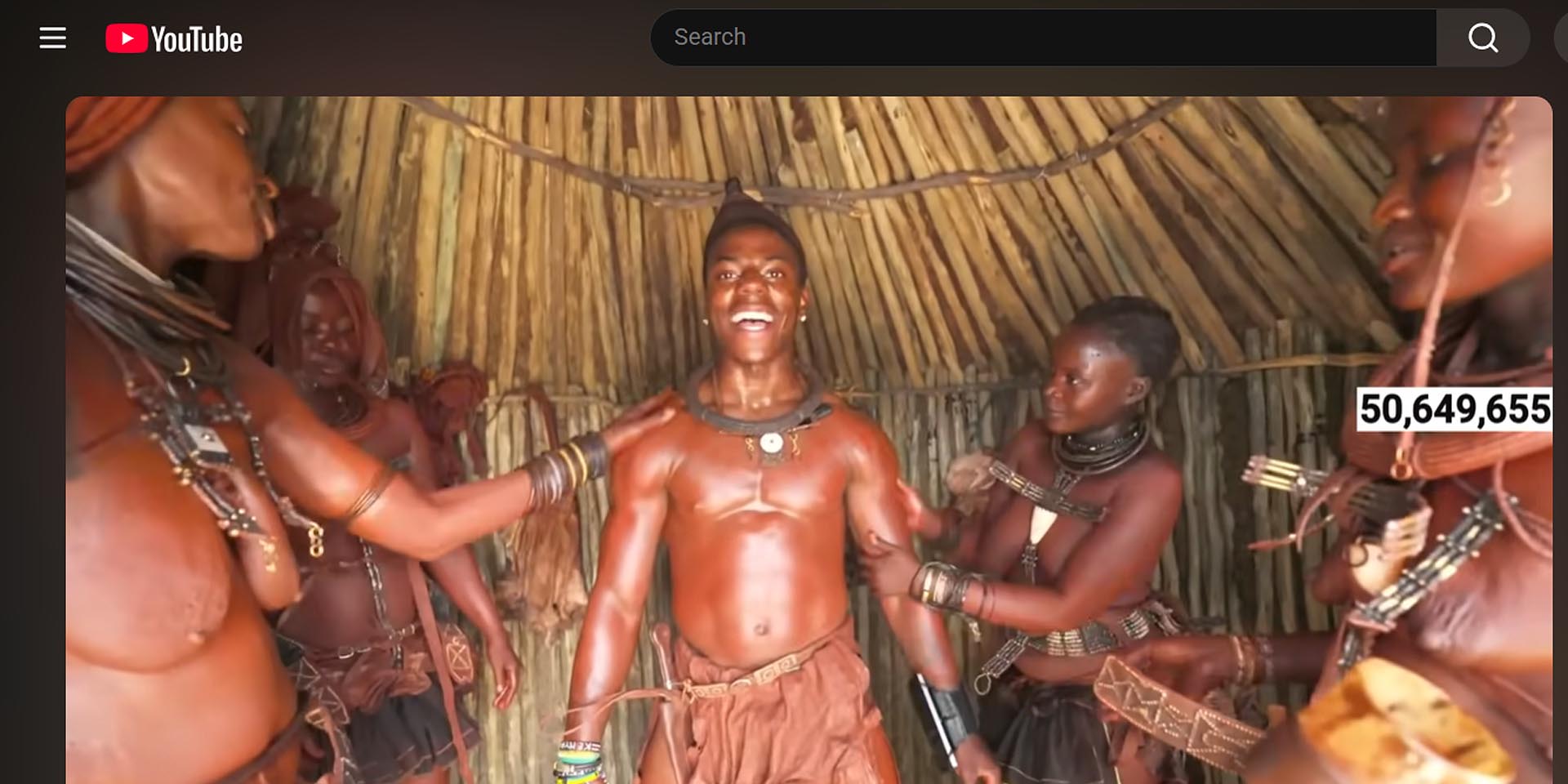 Himba women apply traditional thick skin cream of ghee and ochre powder to IShowSpeed's body Photo Screenshot IShowSpeed stream on YouTube